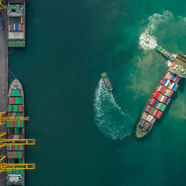 Container ship in export and import business and logistics. Shipping cargo to harbor by crane. Water transport International. Aerial view and top view.